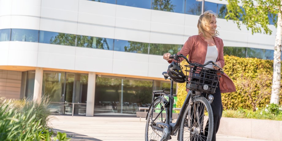 Medarbetare som promenerar med sin cykel.