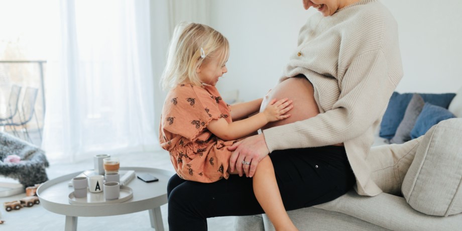 gravid mamma med barn i knät