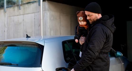 Pappa med bebis tankar bilen.