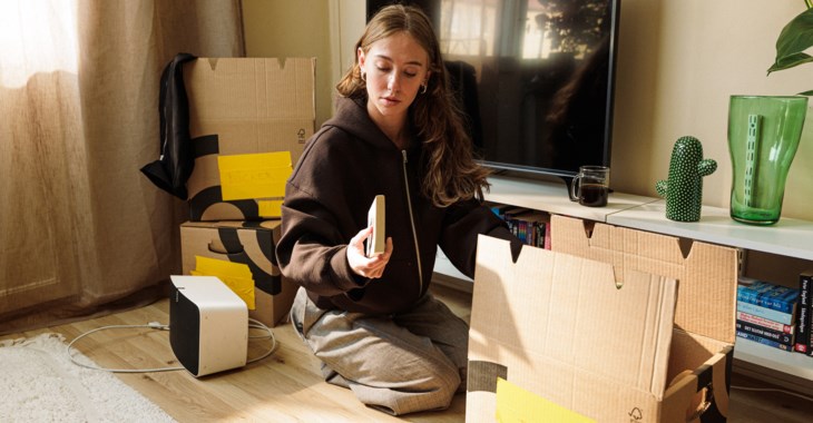 Ung tjej som packar upp saker från en flyttlåda.