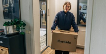 Tjej som bär in en flyttkartong.