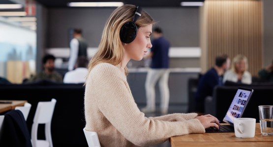 Kvinna som arbetar vid laptop i kontorsmiljö.