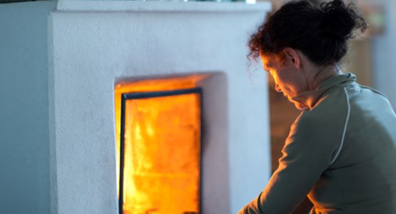 Kvinna eldar i öppen spis.