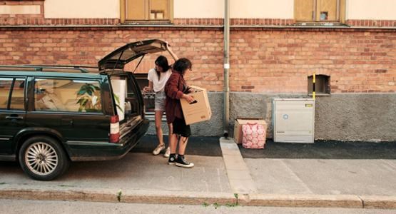 Tjejer bär flyttlådor.