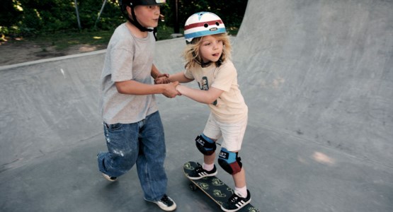 barn med hjälm som åker skateboard