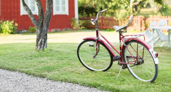 En cykel står parkerad på en gräsmatta i solskenet.
