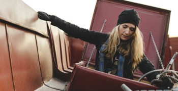 Kvinna som klättrar upp på ett tak.