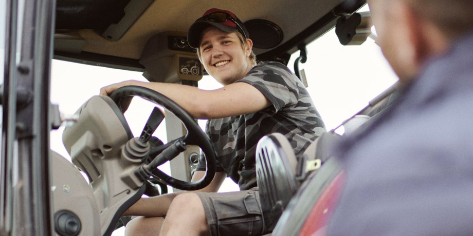 Ung lantbrukare i traktor, foto.