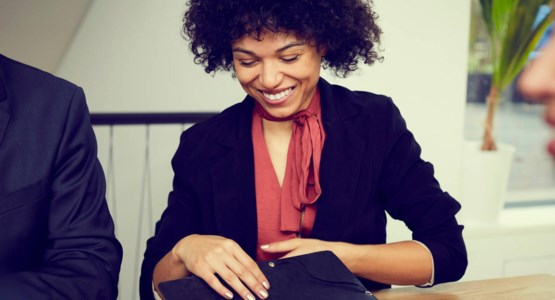 Tre glada personer i möte på kontoret, fotografi.