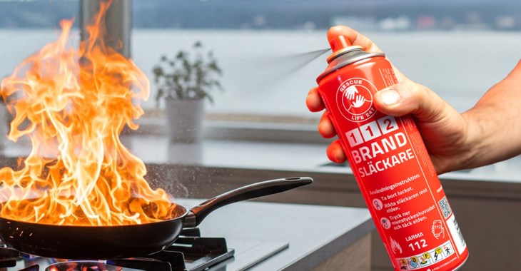 Bild på en hand som sträcker sig mot en 112 Brandsläckare framför en husbil.