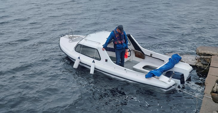 Man tömmer sin båt på vatten i storm