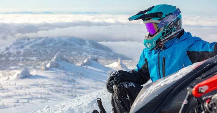 En person som kör en snöskoter i vinterlandskap