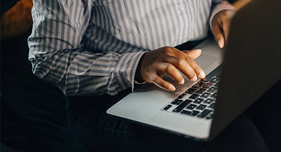 En person som sitter vid datorn och skriver.