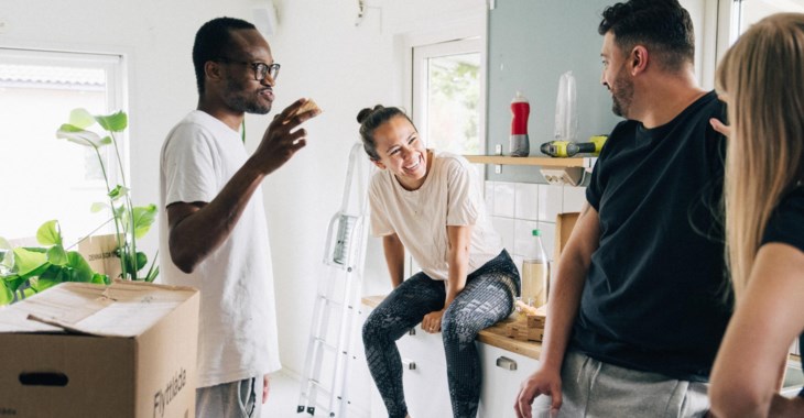 Fyra unga människor pratar i köket.