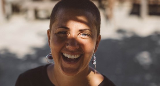 Kvinna skrattar i solljus.