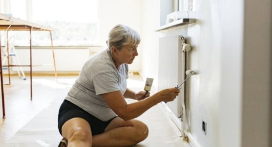 Gråhårig kvinna målar om ett element.