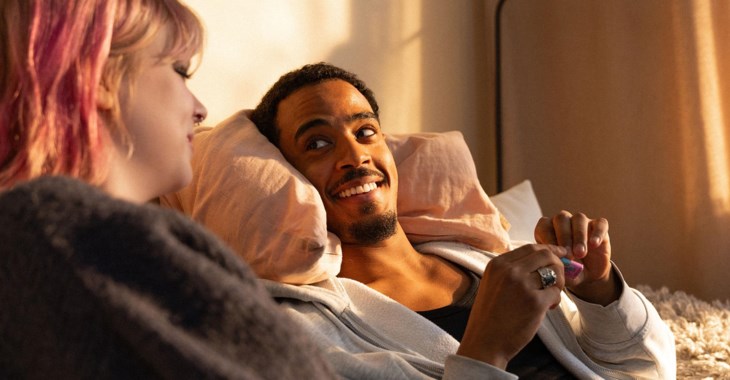 En tjej och en kille samtalar i en soffa.