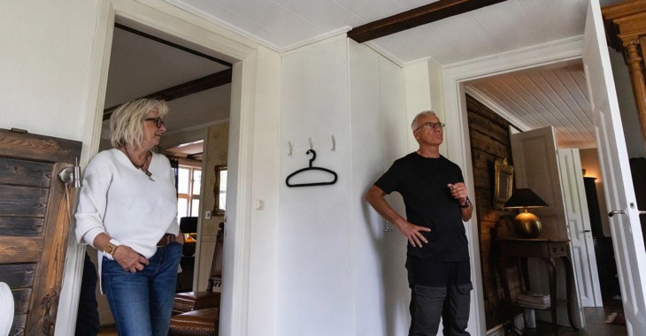 En kvinna och man står i sitt hus 