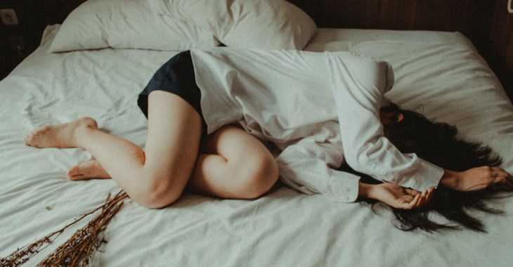 Foto på en tjej som ligger på en säng.