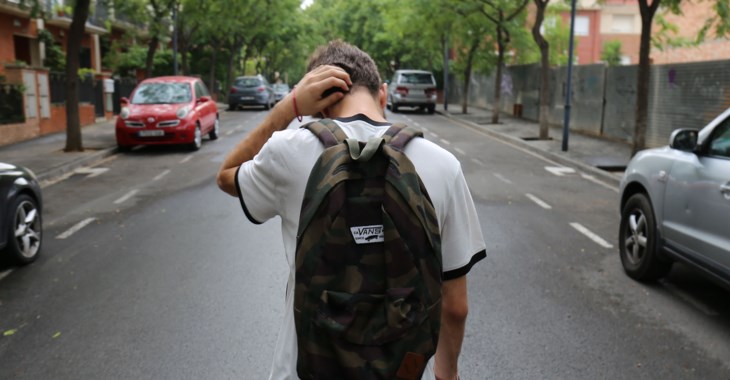 Foto på kille som går med ryggsäck.