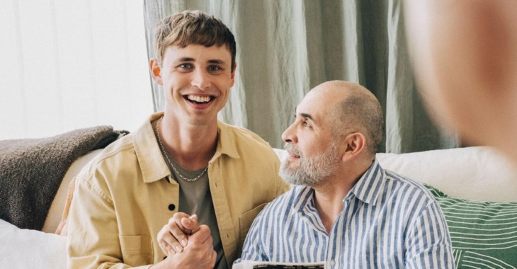 En son sitter med sin pappa i soffan och har ett glatt samtal.