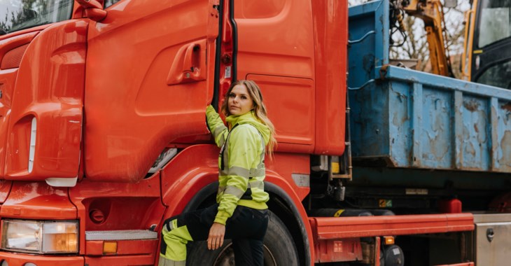 Kvinna står vid dörren till ett tungt fordon
