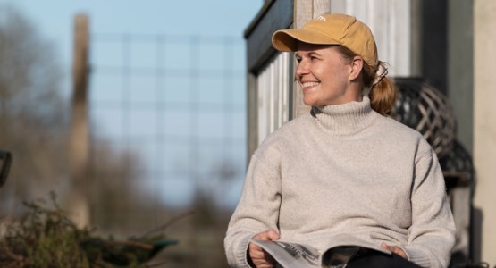 Kvinna sitter utomhus och läser