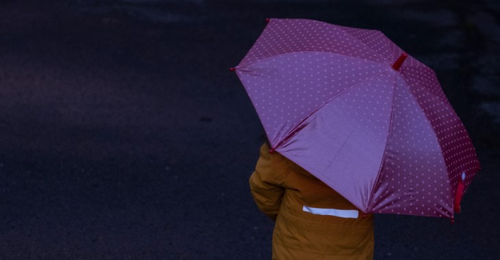 Barn på promenad i mörkret med reflexparaply.
