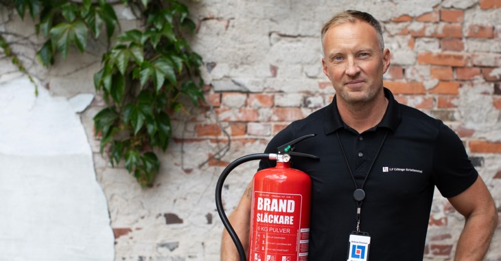 Andreas Nilsson, rådgivare skadeförebygg, på LF Göinge-Kristianstad står med håller i en röd brandsläckare.