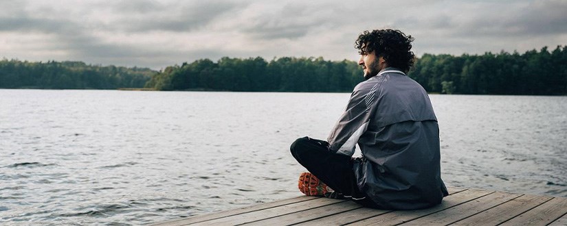 En man som sitter på en brygga, foto.