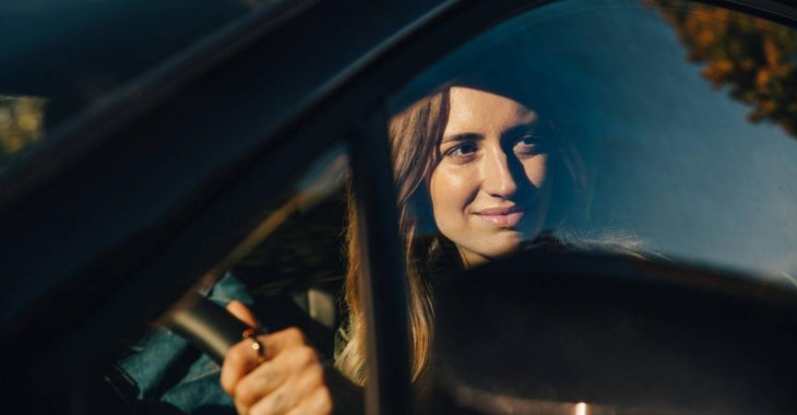 Glad kvinna i bil som valt att byta bilförsäkring till LF.