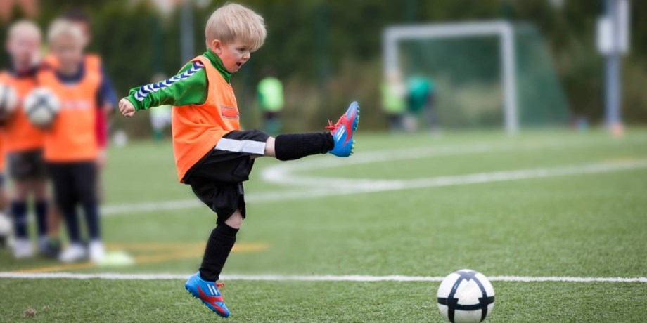 Lite kille spelar fotboll.