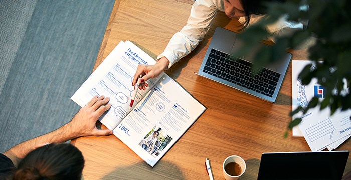 Två personer tittar i broschyr tillsammans.