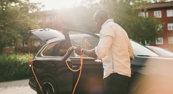 Man som laddar elbil.