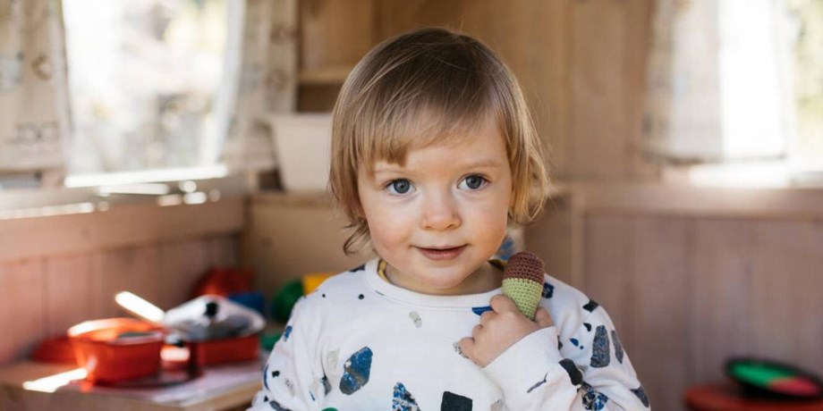 Ett glatt barn som leker, foto. 