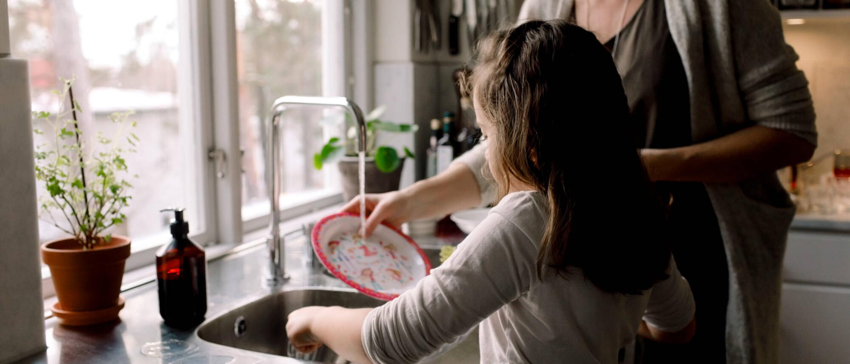 En ung tjej diskar tillsammans med sin mamma.
