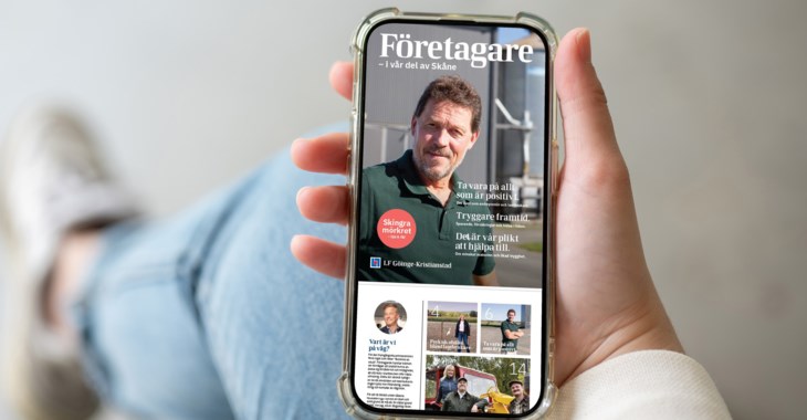 En person läser företagstidningen i mobilen.