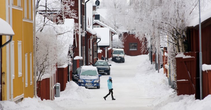 Snöig vintergata med hus 