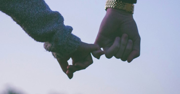 Två händer som krokar i varandra.