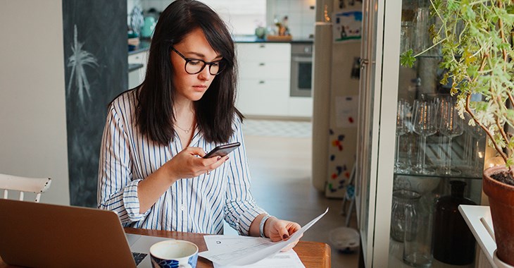 Kvinna tittar på sin mobiltelefon