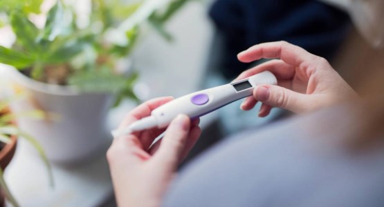 En kvinna håller i ett graviditetstest.