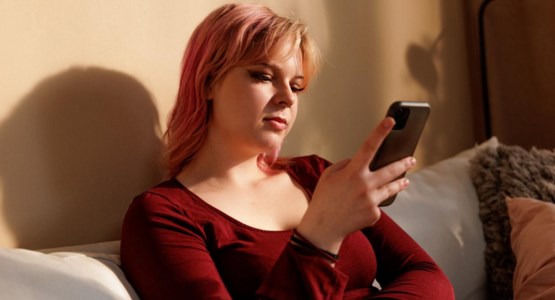 Kvinna tittar i mobilen.