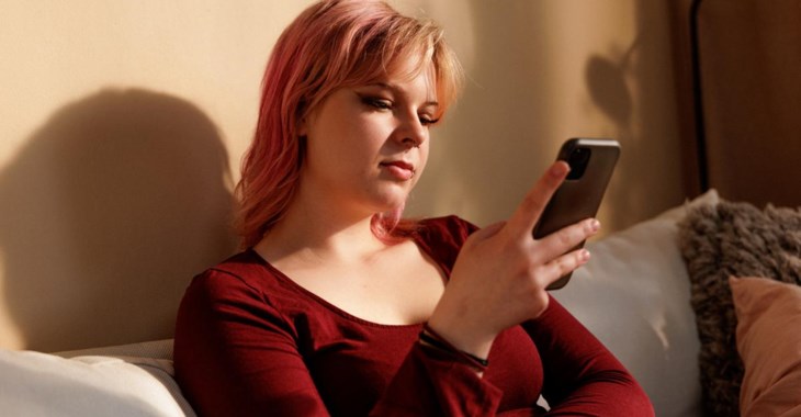 Kvinna tittar i mobilen.