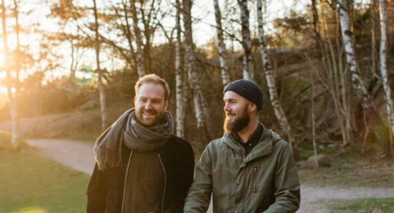 Två män på promenad med barnvagn.