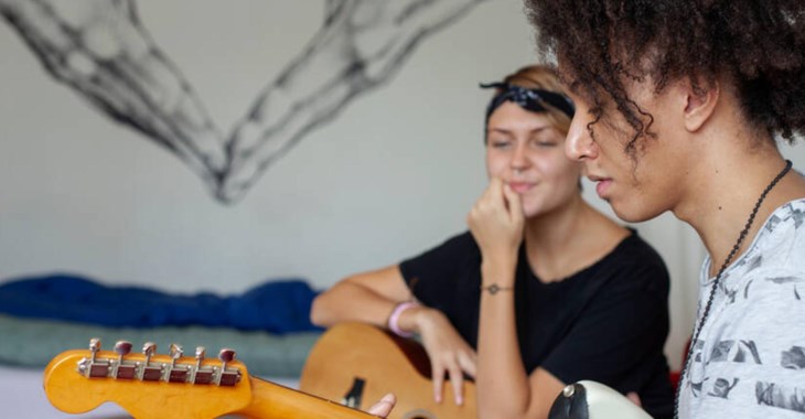 Foto på två tjejer som spelar gitarr.