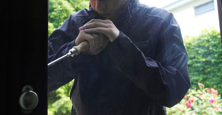 Inbrittstjuv som bryter upp ett läs på en ytterdörr.