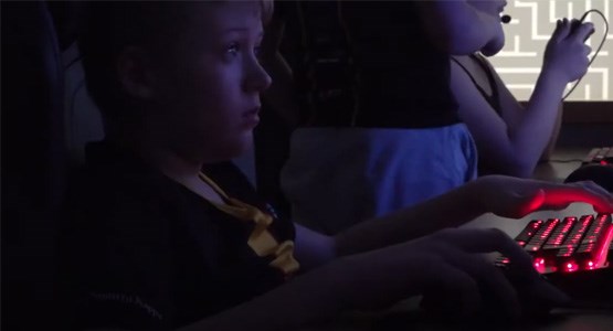 Pojke spelar datorspel på ett gamingcafé.