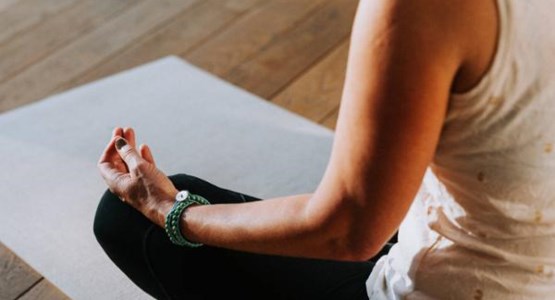 Kvinna som yogar och mediterar.