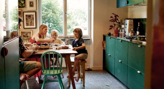 Foto på familj som sitter i köket.