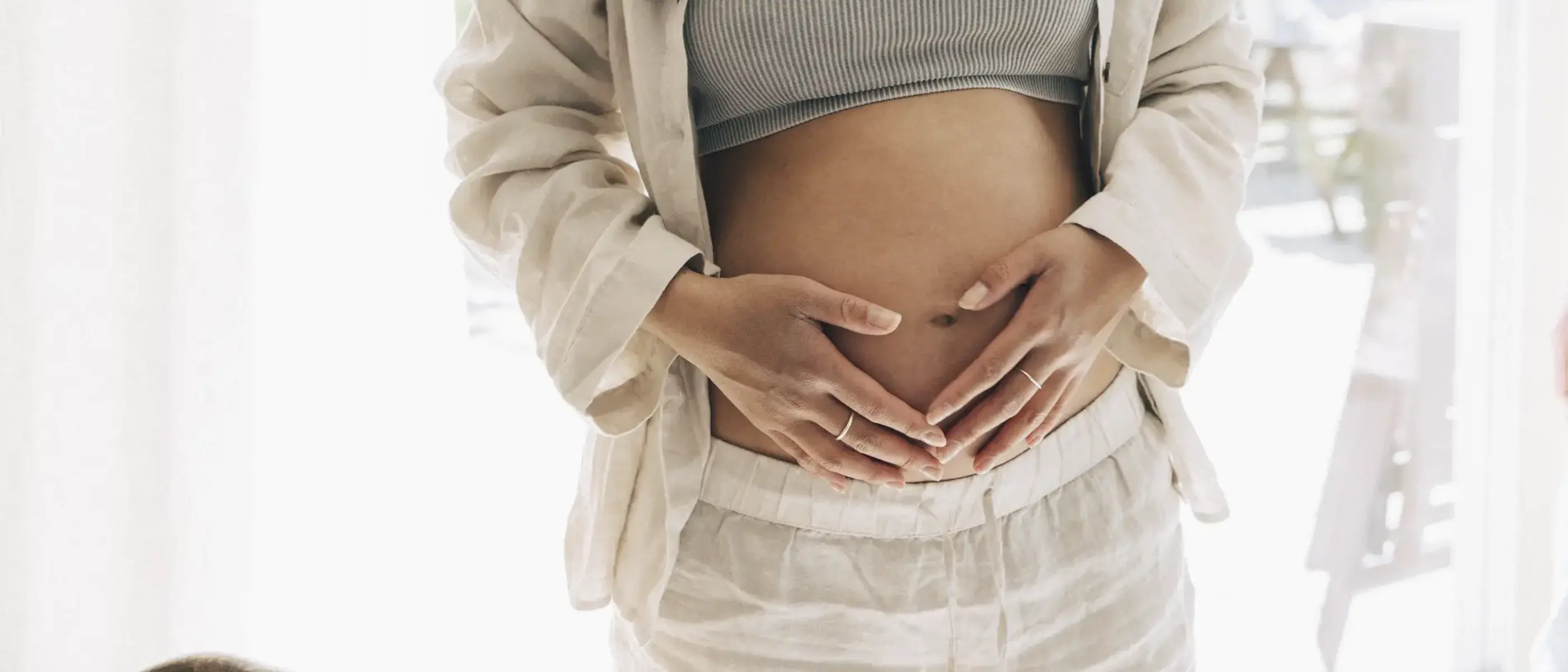 En gravid kvinna håller om sin mage.